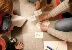 Dzieci układające karty z numerami zadań do rozwiązania