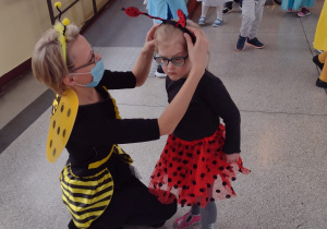Przebrane postacie: Pszczółka i Biedronka na korytarzu szkolnym